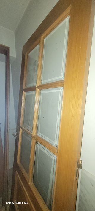 Puerta de madera con cristal con sus marcos.