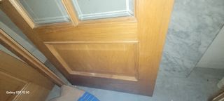 Puerta de madera con cristal con sus marcos.