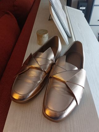 Zapatos planos con un rosa dorado.