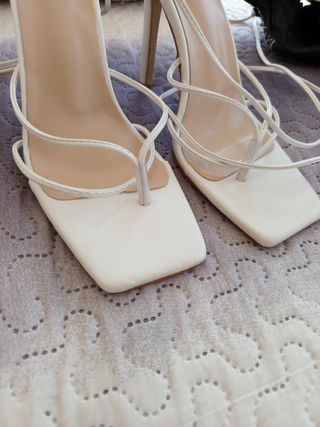 Sandalias blancas altas se atan ala pierna..