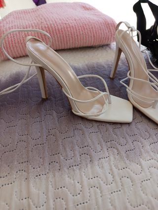 Sandalias blancas altas se atan ala pierna..