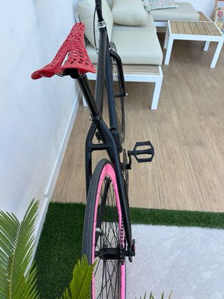 Bicicleta fixie. Negra con detalles en rosa.