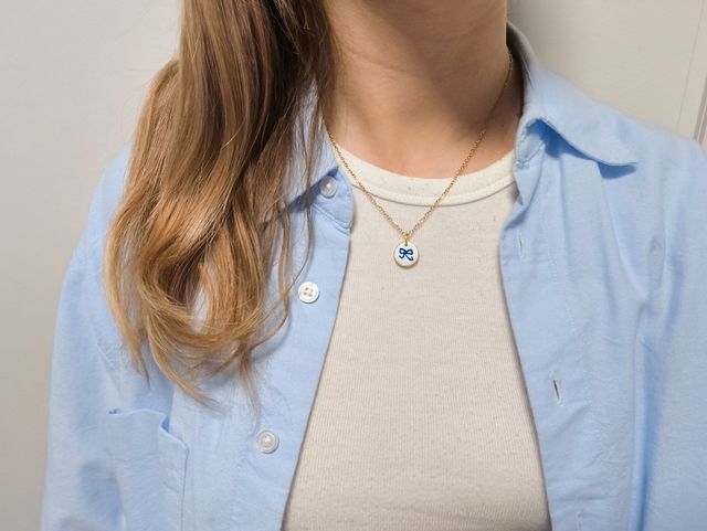 Collar con dije de lazo azul y dorado