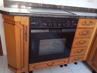 Cocina completa, mesa de cocina y sillas.