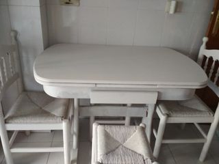 Cocina completa, mesa de cocina y sillas.