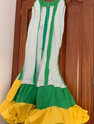 Traje de flamenca verde con detalles amarillos.