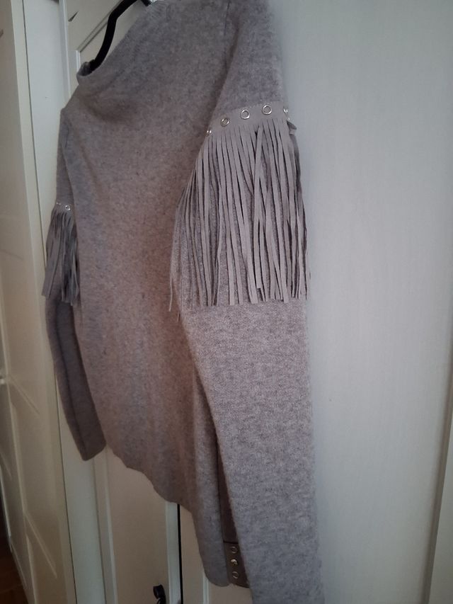 Chaqueta gris con flecos.