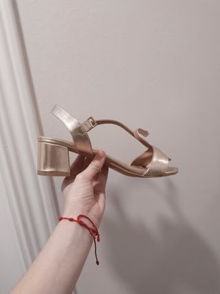 Sandalias doradas Riando tacón bajo. 