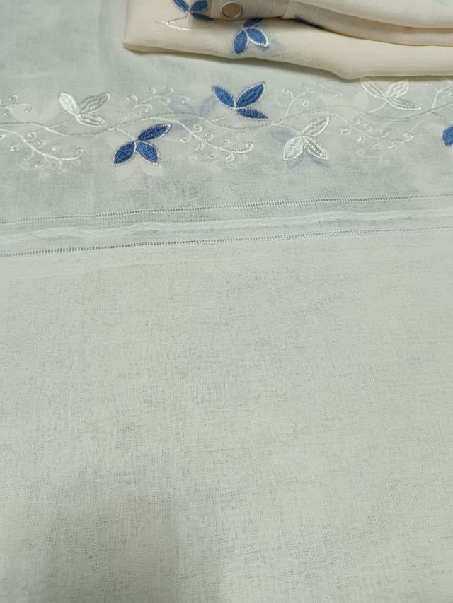 Cortinas beige y azul, con faldón decorativo.