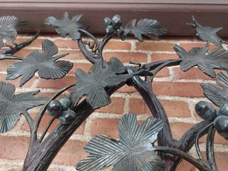 Puerta de hierro forjado con motivos de viñedo.