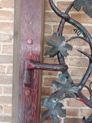 Puerta de hierro forjado con motivos de viñedo.