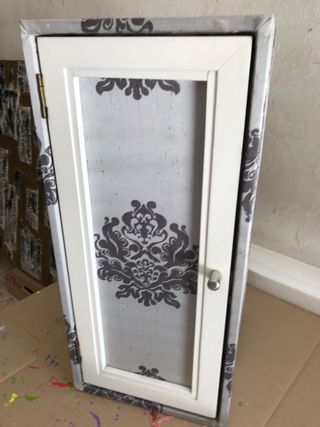 Mueble auxiliar blanco . esta tapizado .