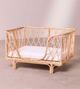 Cama mimbre beige para perros pequeños.