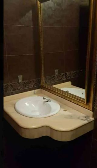 Encimera mármol beige con lavabo.
