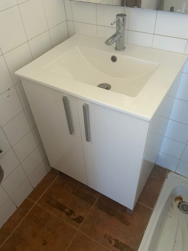 Mueble lavabo blanco con grifo