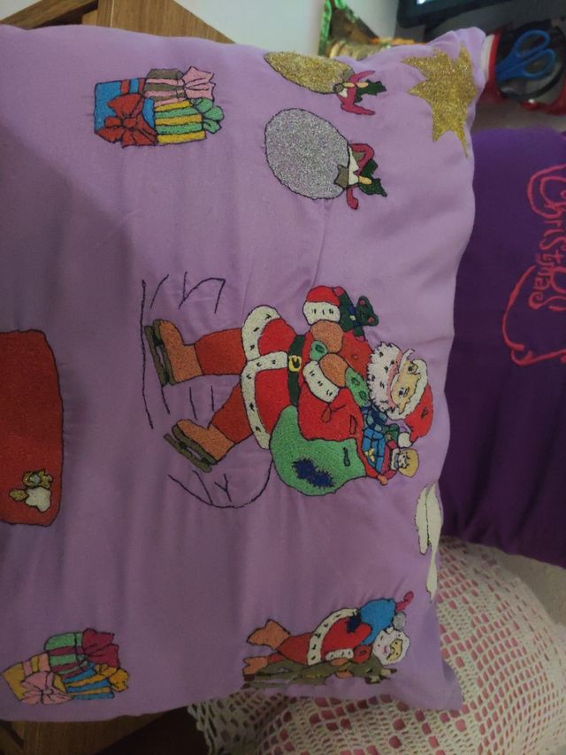Dos cojines bordados a máquina y uno de ganchillo.