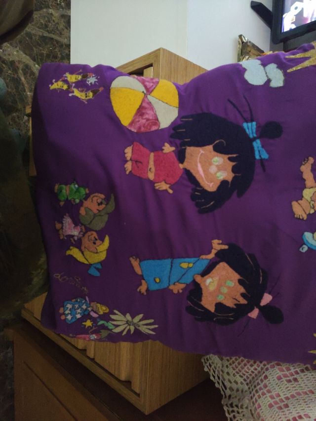 Dos cojines bordados a máquina y uno de ganchillo.