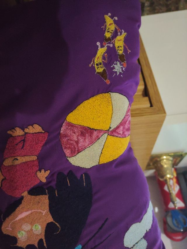 Dos cojines bordados a máquina y uno de ganchillo.