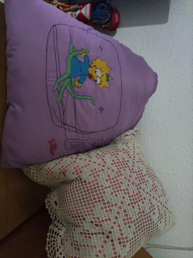Dos cojines bordados a máquina y uno de ganchillo.