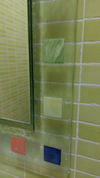 Espejo de baño con marco de vidrio templado.