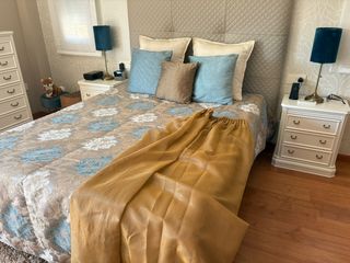 Colcha azul y dorada, junto fundas cojin y cortina