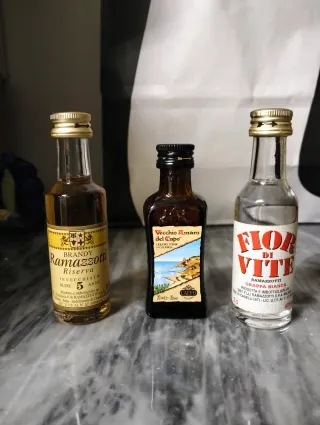 Tre bottiglie mignon vintage vuote.