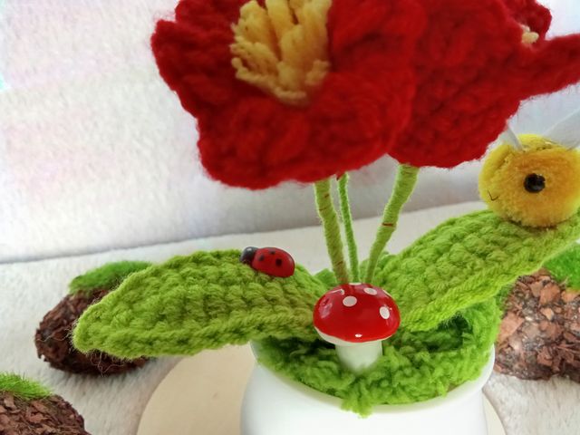 Planta de flores rojas de crochet con adornos