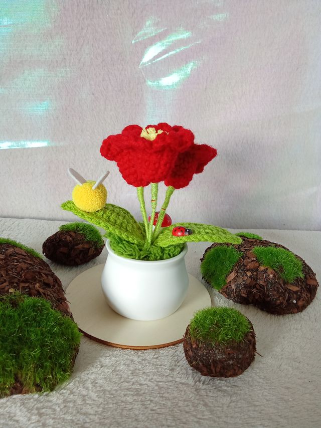 Planta de flores rojas de crochet con adornos