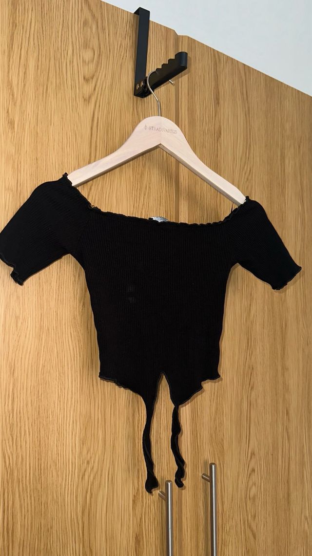 Top negro de hombros caídos