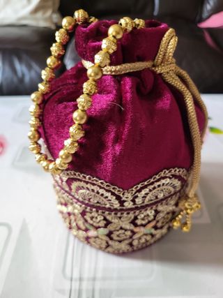 Bolso de mano morado con dorado