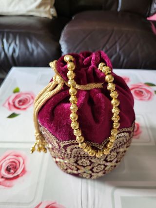 Bolso de mano morado con dorado