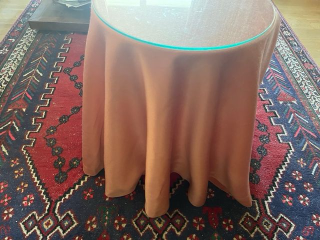 Mesita camilla con tapade cristal y faldon rosa.