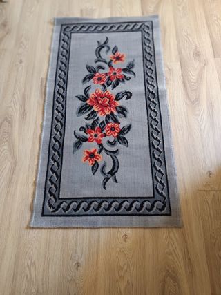 Alfombra gris con flores rojas