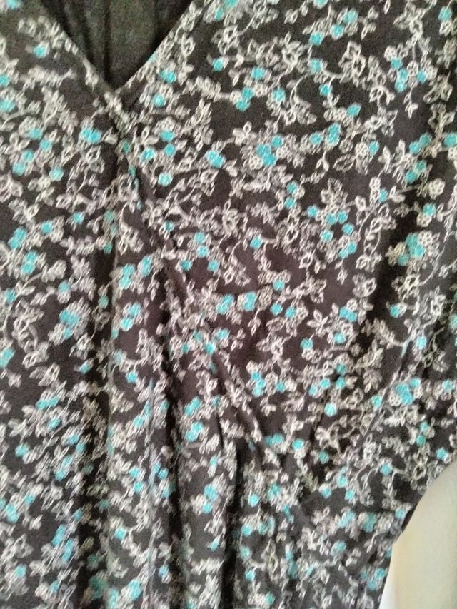 Maglia fiori turchese sfondo marrone