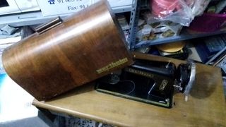 Máquina de coser antigua sobre tablero y hierro de