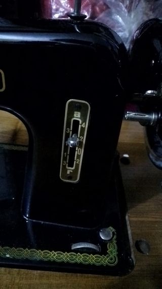 Máquina de coser antigua sobre tablero y hierro de