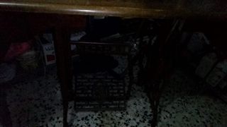 Máquina de coser antigua sobre tablero y hierro de