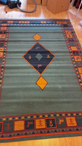Alfombra étnica verde y naranja.