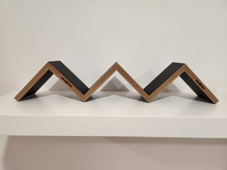 Estantería negra. Forma uve doble o escalera.