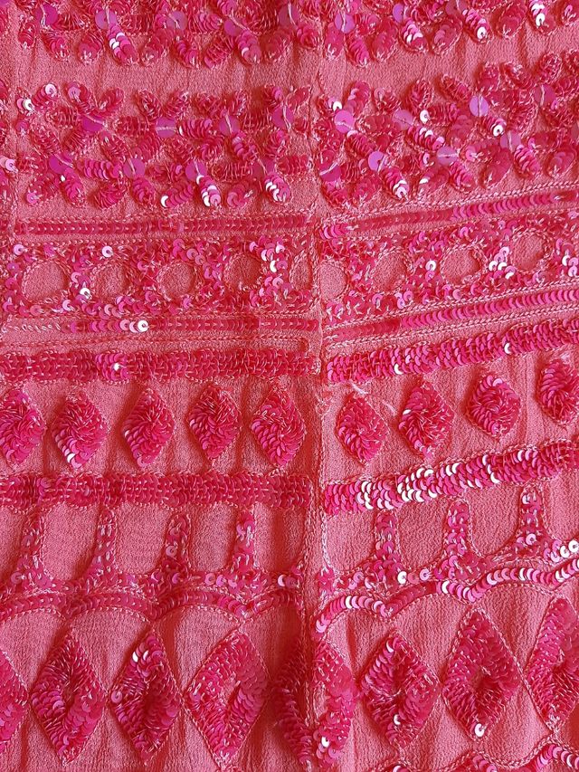 Vestido largo coral con flecos.