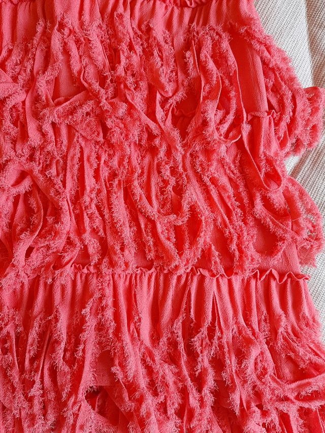 Vestido largo coral con flecos.