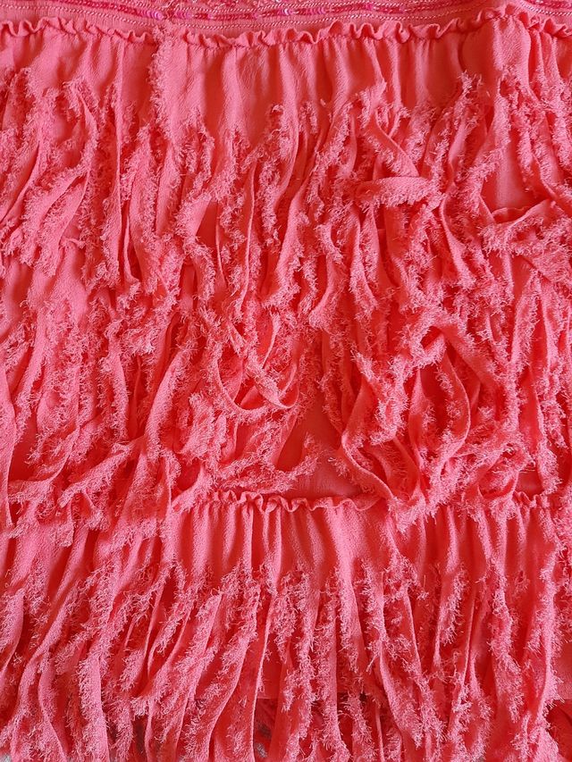 Vestido largo coral con flecos.