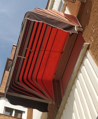 Toldo ventana rayas naranja-marron.