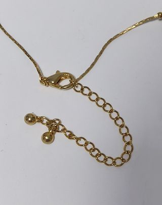 Gargantilla dorada con perlas de color bronce.