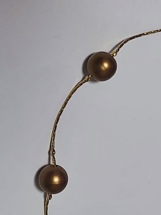 Gargantilla dorada con perlas de color bronce.