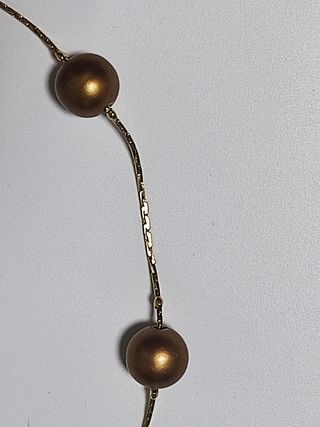 Gargantilla dorada con perlas de color bronce.