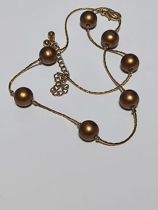 Gargantilla dorada con perlas de color bronce.