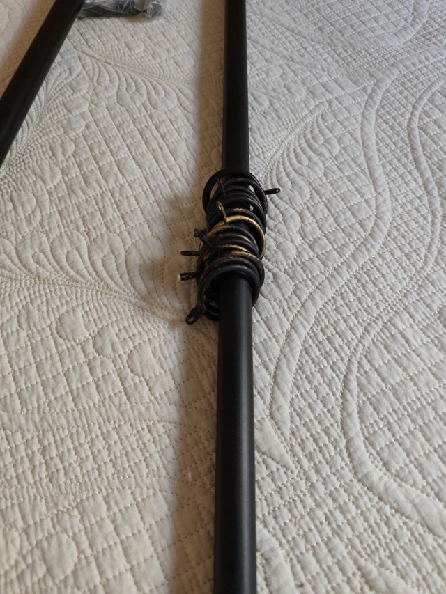 Riel de forja negro con anillas doradas.