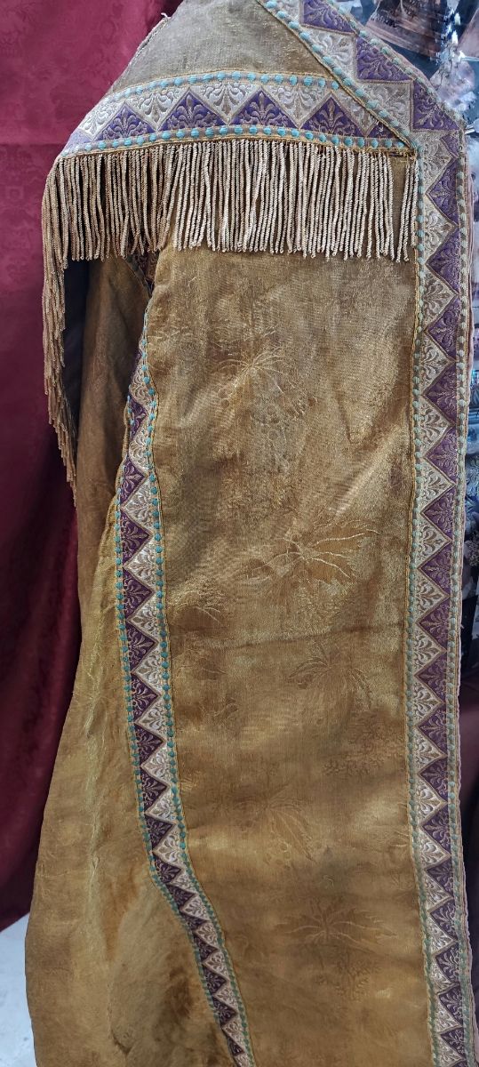 Capa pluvial antigua dorada