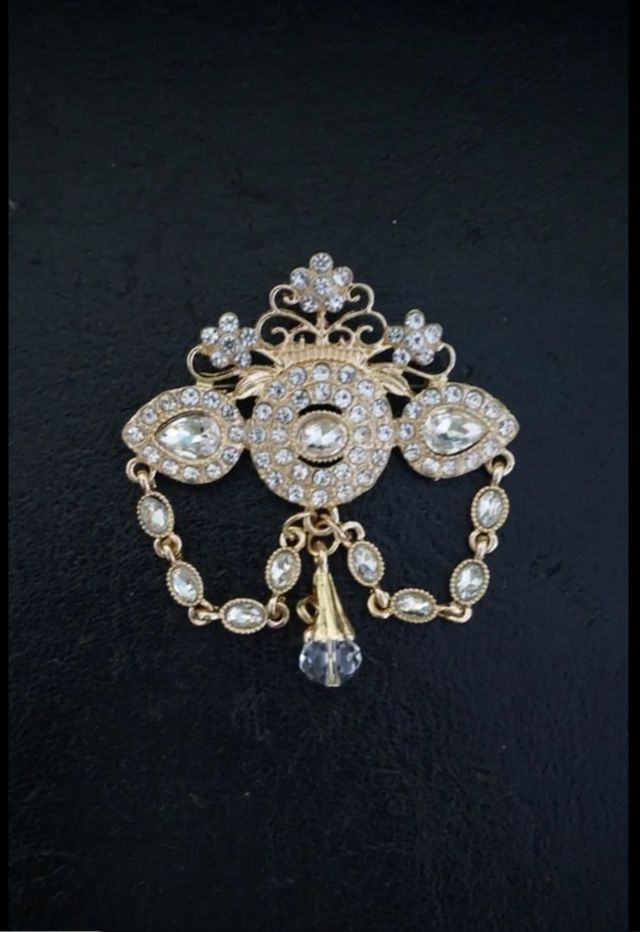 Broche dorado con pedrería.